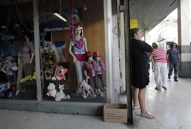 A woman is pictured in front of a store in Havana December 17, 2014. (Photo by Reuters/Stringer)