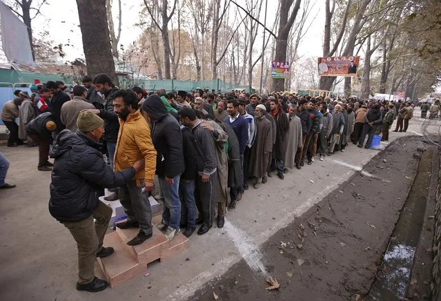Indian policemen frisk Kashmiri men at the entrance of the cricket stadium where Indian Prime Minister Narendra Modi is scheduled to address a rally in Srinagar, November 7, 2015. Modi pledged 800 billion rupees ($12.10 billion) in funds to bolster development and economic growth in Kashmir, a year after the worst flooding in more than a century destroyed half a million homes there. (Photo by Danish Ismail/Reuters)
