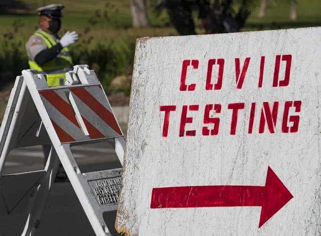 A COVID testing sign directs drivers waiting in line to get a free COVID-19 self-test at Dodger Stadium in Los Angeles, Tuesday, December 1, 2020. California has asked hospitals to ramp up their coronavirus testing amid a surge of new cases, urging them to test health care workers at least once per week while testing all new patients before admitting them. (Photo by Damian Dovarganes/AP Photo)