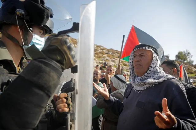 A Palestinian demonstrator argues with an Israeli border police member during a protest against Jewish settlements, in Beit Dajan in the Israeli-occupied West Bank on November 13, 2020. (Photo by Raneen Sawafta/Reuters)