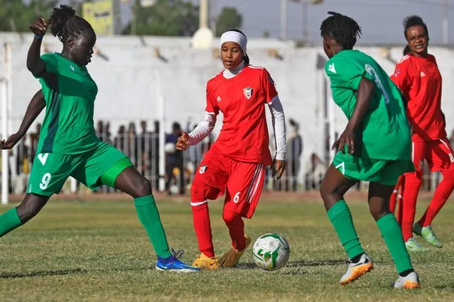 South Sudan's Chieng Thomas Manyol Riek (L) vies for the ball against Rwan Abdalminim of Sudan (C) during a FIFA women's football friendly match between Sudan and South Sudan at Jebel Awliaa stadium in Sudan's capital Khartoum on February 16, 2022. Sudan's women national team was officially created in 2021, around two years following the ouster of Islamist president Omar al-Bashir whose three-decade rule which saw little freedoms for women. The team has since took part of the Arab Women's Cup 2021 playing against Egypt, Tunisia, and Lebanon. They also played Algeria in October, and South Sudan this month. (Photo by Ashraf Shazly/AFP Photo)