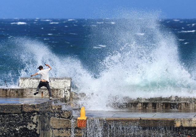 A man reacts as waves crash against the Kalk Bay harbour wall during high tide in Cape Town, South Africa, on October 19, 2025. (Photo by Esa Alexander/Reuters)