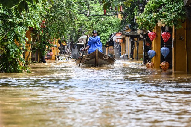A man navigates a flooded street on a boat following heavy rains in Hoi An on October 30, 2025. Vietnam's coastal provinces have been lashed by heavy rains since October 26, with a record of up to 1.7 metres (five feet seven inches) falling over 24 hours. (Photo by Nhac Nguyen/AFP Photo)