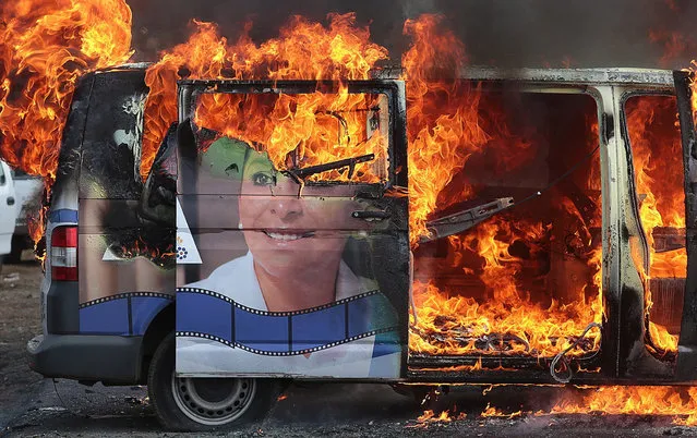 A vehicle of the senator candidate for the coalition “Michoacan al Frente” Alma Mireya Gonzalez Sanchez burns during an event during her campaign the municipality of Nahuatzen, Michoacan, Mexico, 15 May 2018. The vehicle was set on fire by local residents among rising tensions ahead of the elections that will take place on 01 July 2018 to elect the president of Mexico, the deputies, the senators, eight governors and the head of government of Mexico City, among other 3,400 positions. (Photo by  Ivan Villanueva/EPA/EFE)