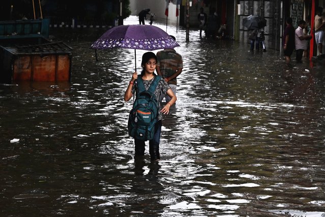 A woman wades across a waterlogged street after heavy monsoon rains in Kolkata, India on September 23, 2025. (Photo by Dibyangshu Sarkar/AFP Photo)
