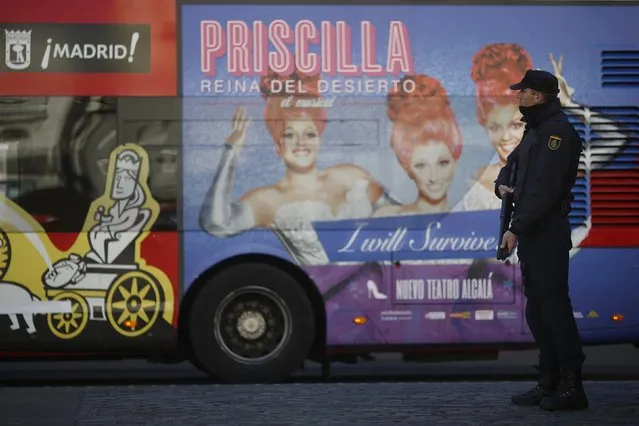 A police officer stands guard as a tourist bus drives away at Madrid's landmark Puerta del Sol Square January 9, 2015. Spain said it was beefing up security around key infrastructure after an armed attack on French magazine Charlie Hebdo in Paris on Wednesday in which at least 12 people were killed. (Photo by Susana Vera/Reuters)