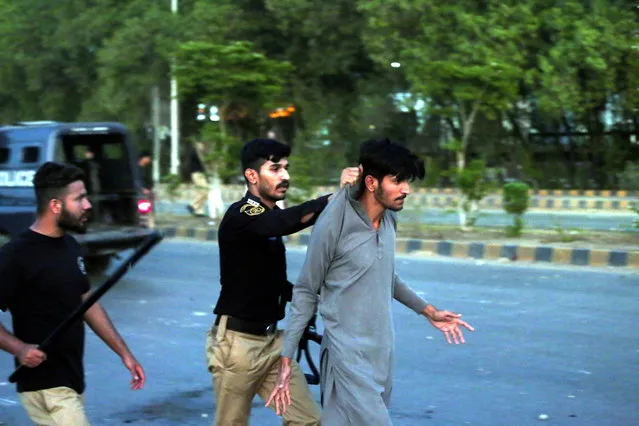 A police officer detains a person during protest by supporters of Pakistan's former Prime Minister Imran Khan against his arrest, in Karachi, Pakistan, 09 May 2023. Khan, the chairman of Pakistan Tehreek-e-Insaf, was taken into custody by the National Accountability Bureau (NAB) on 09 May outside the Islamabad High Court, where he had arrived to appeal for bail in multiple cases filed against him. The arrest came after Khan's ouster from power in April 2020 following a failed vote of confidence in parliament. (Photo by Rehan Khan/EPA)
