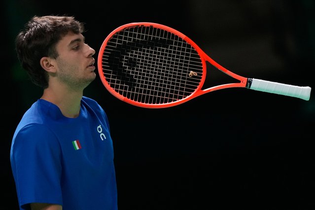 Italy's Flavio Cobolli throws his racket during a Davis Cup singles semifinal match against Belgium's Zizou Bergs in Bologna, Italy, November 21, 2025. (Photo by Luca Bruno/AP Photo)