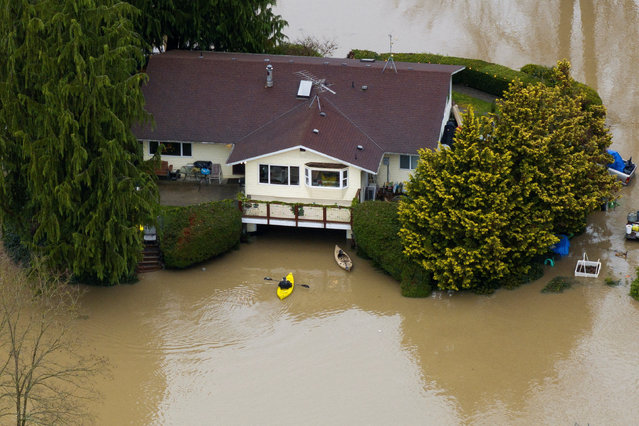 A drone view shows a kayaker floating in front of a home flooded by the Snohomish River, as an atmospheric river brings rain and flooding to the Pacific Northwest, in Snohomish, Washington, U.S., December 11, 2025. (Photo by David Ryder/Reuters)