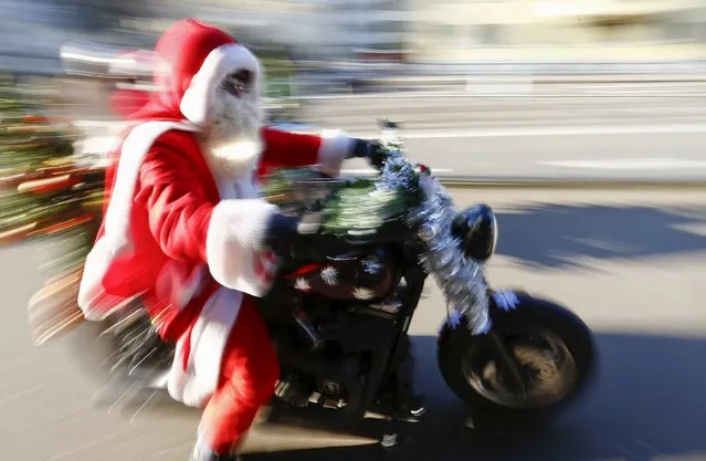 A Harley Davidson biker is dressed as Santa Claus as he takes part in a charity ride in Zurich, Switzerland December 6, 2015. (Photo by Arnd Wiegmann/Reuters)