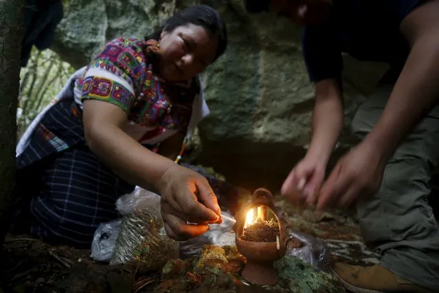 Mayan spiritual leader Juana Justa Yax Tale, from Guatemala, (L), lights a fire before a ceremony in honor of Mayan ancestors in Madruga, Cuba, December 8, 2015. (Photo by Reuters/Stringer)