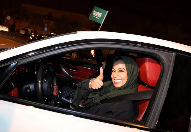 A Saudi woman celebrates as she drives her car in her neighborhood, in Al Khobar, Saudi Arabia on June 24, 2018. Saudi Arabia had a blanket ban on women driving, with those caught behind the wheel detained. The strict rules in the Islamic country were enforced despite neither Islamic or Saudi law explicitly prohibiting women from driving. The ban had the backing of powerful ultraconservative clerics who argued such acts would corrupt society and lead to sin. One cleric even claiming getting behind the wheel could damage women's ovaries and damage fertility. For decades women drivers have faced arrest and harassment with several high profile protests. In 1990 a major protest saw 50 women drivers travel through the streets of the country's capital, Riyadh. They were arrested and lost their passports and jobs. In 2011 a woman was sentenced to 10 lashes for driving - although the late King Abdullah overturned the sentence. A royal order in 2017 decreed that both women and men should be issued driving licences. The change came into force in June 2018. (Photo by Hamad I Mohammed/Reuters)