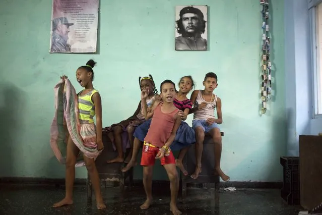 Children sing during a rehearsal of the Contemporary Haitian dance in front of pictures of former Cuban president Fidel Castro (L) and Cuba's revolutionary hero Ernesto “Che” Guevara in a communal center in downtown Havana January 30, 2015. (Photo by Alexandre Meneghini/Reuters)