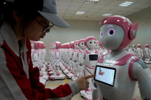 A worker puts finishing touches to an iPal social robot, designed by AvatarMind, at an assembly plant in Suzhou, Jiangsu province, China July 4, 2018. Designed to offer education, care and companionship to children and the elderly, the 3.5-feet tall humanoid robots come in two genders and can tell stories, take photos and deliver educational or promotional content. (Photo by Aly Song/Reuters)