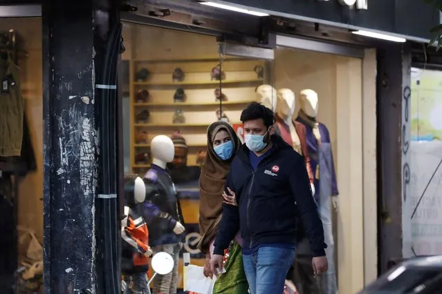 A couple wearing protective masks walk along a market, as the outbreak of coronavirus disease (COVID-19) continues, in Karachi, Pakistan on December 29, 2020. (Photo by Akhtar Soomro/Reuters)