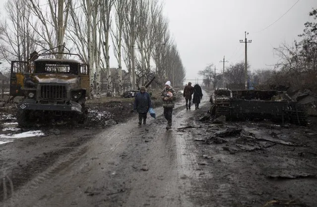 Residents walk in a street in the town of Vuhlehirsk, eastern Ukraine, Tuesday, February 10, 2015. Fighting in eastern Ukraine intensified on Tuesday ahead of much-anticipated peace talks, with both sides claiming significant advances. (Photo by Vadim Braydov/AP Photo)