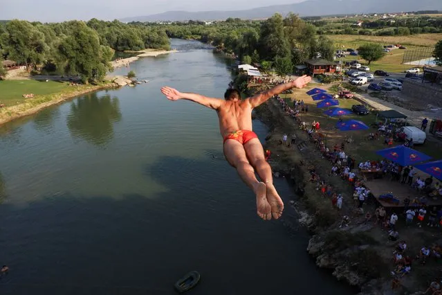 Evald Krnic, a diver from Montenegro, jumps from a bridge during a competition on the White Drin River, near the town of Gjakova, Kosovo on July 23, 2023. (Photo by Fatos Bytyci/Reuters)