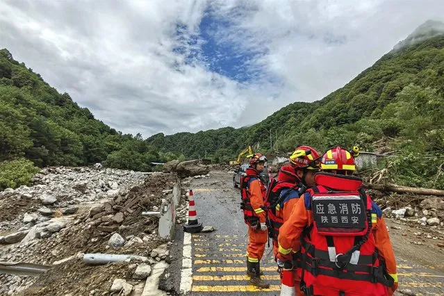 In this photo released by Xinhua News Agency, rescue workers gather at the aftermath of a mudslide in Weiziping village of Luanzhen township on the outskirts of Chang'an district, Xi'an of northwestern China's Shaanxi Province on Saturday August 12, 2023. The mudslide caused by torrential rains killed at least two people on the outskirts of Xi'an in western China, an official news agency said Saturday, while some trains in the northeast were canceled as a powerful storm lashed the region. (Photo by Zhang BinXinhua via AP Photo)