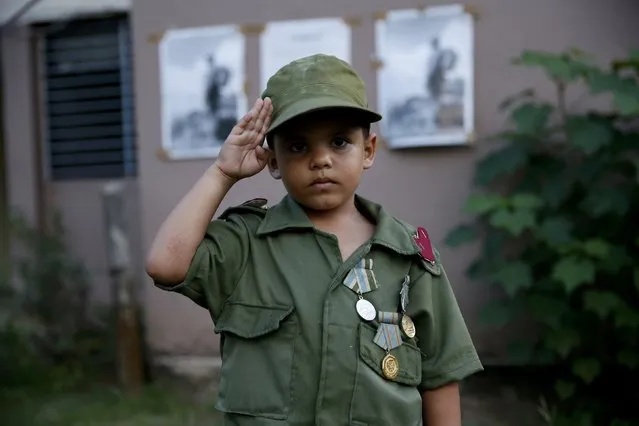 Daniel Hernandez, 4, salutes while awaiting the caravan carrying the late Cuban President Fidel Castro's ashes in Camaguey, Cuba, December 1, 2016. (Photo by Carlos Garcia Rawlins/Reuters)