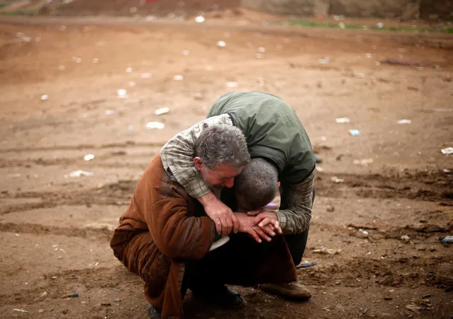 An Iraqi father (L) mourns the death of his son, who was killed during clashes in the Islamic State stronghold of Mosul, in al-Samah neighborhood, Iraq December 1, 2016. (Photo by Mohammed Salem/Reuters)