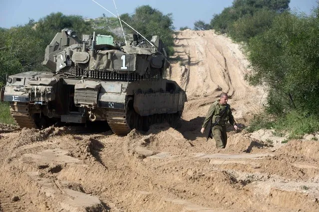An Israeli soldier walks next to a tank near the Israeli border with the northern Gaza Strip near the southern Israeli village of Netiv Haasara on January 13, 2016.
An Israeli air raid in the northern Gaza Strip targeting alleged militants killed one Palestinian and wounded three others, the Israeli army and a Palestinian official said. (Photo by Menahem Kahana/AFP Photo)
