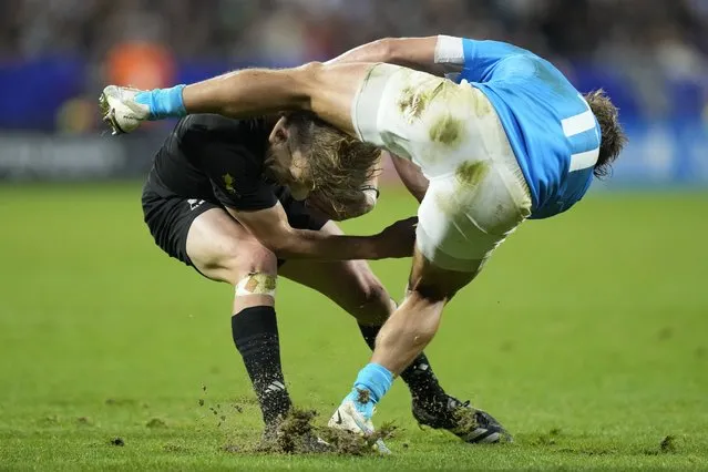 New Zealand's Damian McKenzie, left, is challenged by Uruguay's Nicolas Freitas during the Rugby World Cup Pool A match between New Zealand and Uruguay at the OL Stadium, in Lyon, France Thursday, October 5, 2023. (Photo by Pavel Golovkin/AP Photo)
