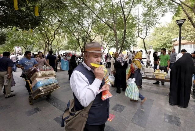 A blind man plays harmonica at the grand  Bazar in central Tehran October 7, 2015. (Photo by Raheb Homavandi/Reuters/TIMA)