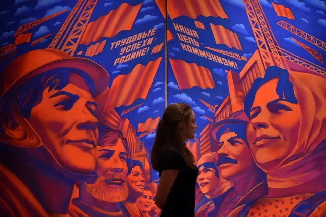 A woman looks at the painting “Implementing the Resolutions of the 26th Party Congress” by Andrei Bondarev at the exhibition “Hyperrealism. When Reality Becomes Illusion” at the Tretyakov Gallery on Krymsky Val in central Moscow on April 1, 2015. The exhibition runs from 13 March to 26 July. (Photo by Kirill Kudryavtsev/AFP Photo)