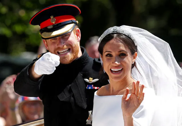 Britain's Prince Harry gestures next to his wife Meghan as they ride a horse-drawn carriage after their wedding ceremony at St George's Chapel in Windsor Castle, May 19, 2018. (Photo by Damir Sagolj/Reuters)