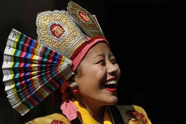 A Tibetan student in a traditional attire laughs as she waits to perform a dance during a special prayer ceremony on the third day of the Tibetan New Year celebrations in Kathmandu, Nepal, Thursday, February 11, 2016. (Photo by Niranjan Shrestha/AP Photo)