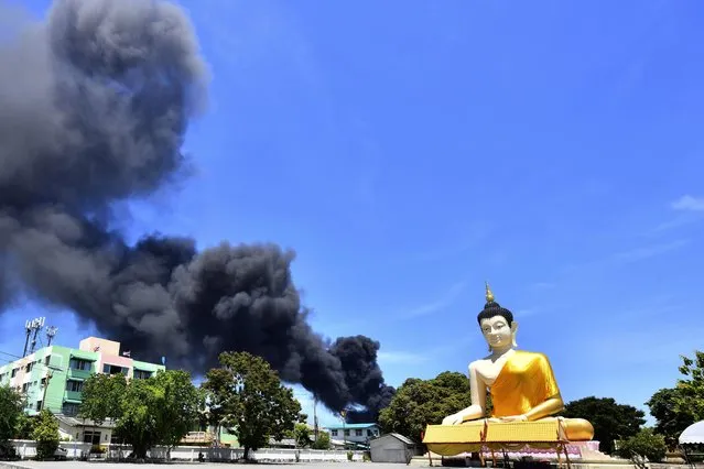 Rising smoke is seen behind the giant Buddha statue in Samut Prakan province, Thailand, Monday, July 5, 2021. (Photo by AP Photo/Stringer)