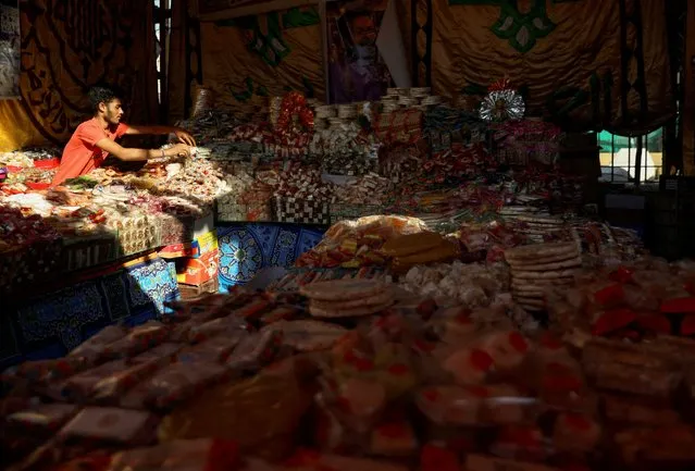 An Egyptian seller waits for customers of traditional handmade sweets at a street market ahead of Mawlid al-Nabi, the birthday of Prophet Mohammad, as according to sellers and customers, prices of raw materials have increased due to the currency crisis, leading to a decrease in demand, in Sayeda Zainab neighbourhood in Cairo, Egypt on September 24, 2023. (Photo by Mohamed Abd El Ghany/Reuters)