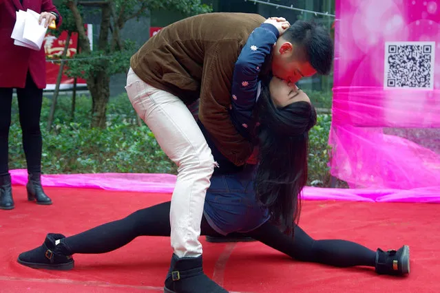 A couple participates in a kissing competition to celebrate Christmas in Wuhan, Hubei province December 24, 2013. The competition required the attendants to kiss in different postures for a prize worth 15,000 Yuan ($2,470), local media reported. (Photo by Reuters/Stringer)