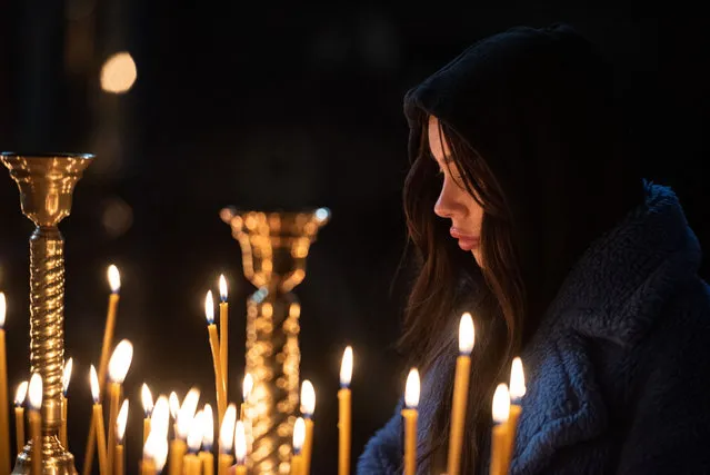A woman prays during Easter church service at the St. Michaels Golden-Domed Cathedral on April 24, 2022 in Kyiv, Ukraine. Orthodox Easter celebrations come as Ukraine marks two months since the start of Russia's February 24 invasion, a war that has killed untold thousands of civilians and soldiers. As Russia concentrates its attack on the country's east and south, Ukrainians elsewhere claim their dead and clean up the damage, striving for a semblance of normalcy in wartime. (Photo by Alexey Furman/Getty Images)