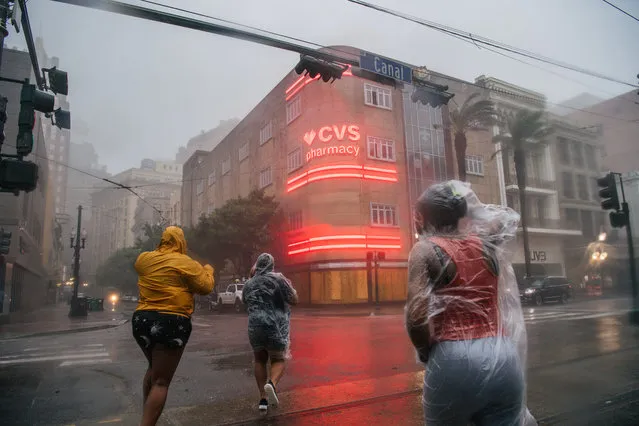 A group of people cross an intersection during Hurricane Ida on August 29, 2021 in New Orleans, Louisiana. Hurricane Ida made landfall earlier today and continues to cut across Louisiana. Hurricane Ida has been classified as a Category 4 storm with winds of 150 mph. (Photo by Brandon Bell/Getty Images)
