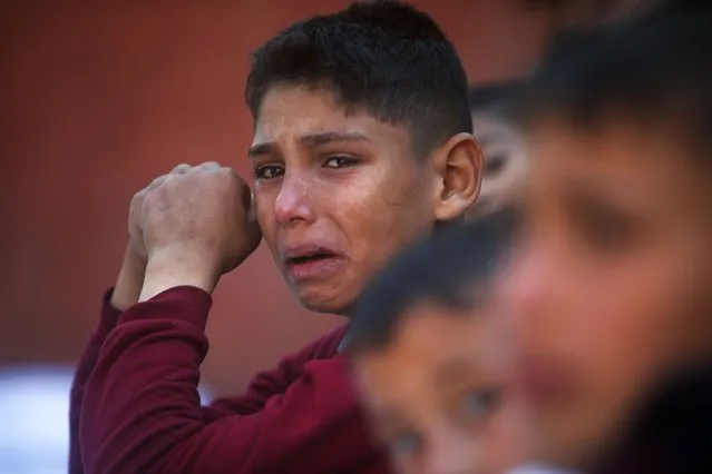 A Palestinian boy cries for his relatives who were killed in the Israeli bombardment of the Gaza Strip, at Nasser hospital in Khan Younis, Friday, December 15, 2023. (Photo by Mohammed Dahman/AP Photo)