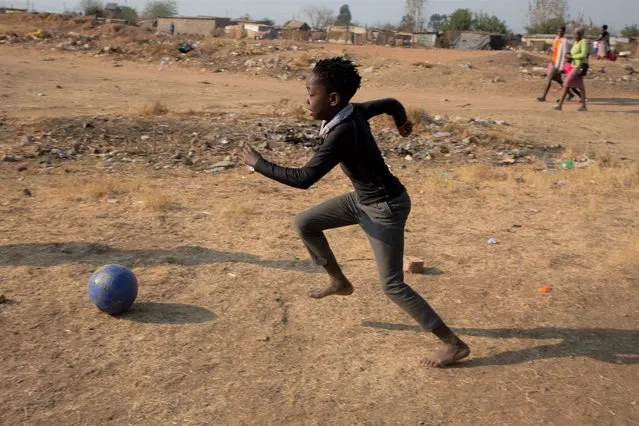 A child plays soccer in the Diepsloot Township, north of Johannesburg, Thursday, August 26, 2021. (Photo by Denis Farrell/AP Photo)