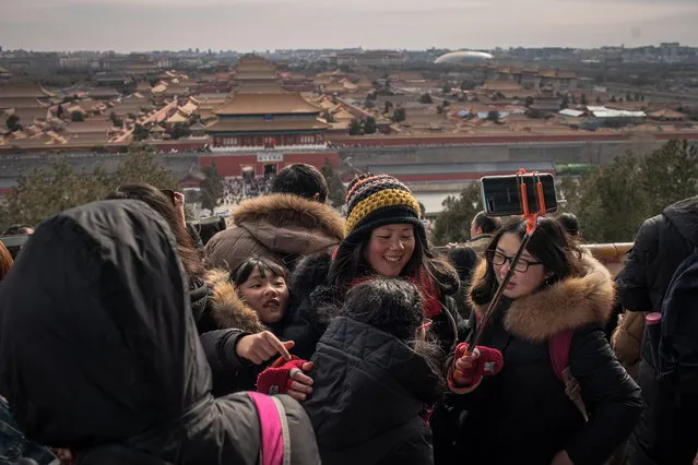 Chinese tourists take selfies at a viewing area of Jingshan Park that overlooks the Forbidden City during the weeklong Lunar New Year's holiday, in Beijing, China, 09 February 2019. Every year millions of Chinese tourists travel around China and overseas for Lunar New Year, or Spring Festival holidays, which began on 05 February 2019 this year marking the Year of the Pig. (Photo by Roman Pilipey/EPA/EFE)