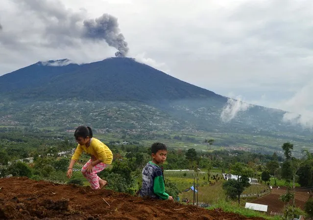 Children play in the shadow of Mount Marapi volcano in Tanah Datar, Indonesia on January 6, 2024. (Photo by Iggoy el Fitra/Antara Foto/Reuters)