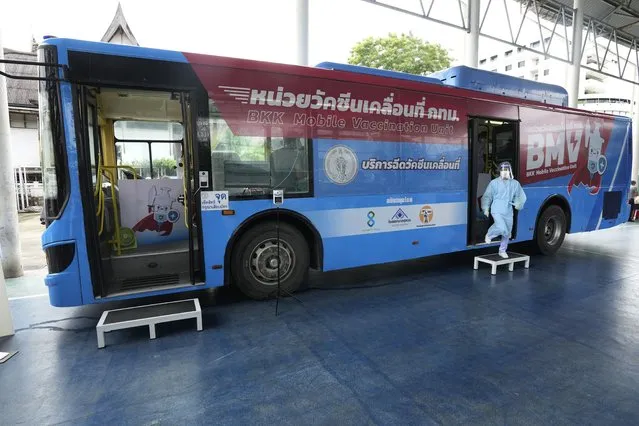 A health worker exits a mobile vaccination unit in Bangkok, Thailand, Wednesday, September 8, 2021. Bangkok health authorities sent out its first mobile vaccination unit to support its vaccination campaign in the community. The city hopes that the converted bus will help health workers reach those with mobility issues, and people with tight work schedules to get vaccinated. (Photo by Sakchai Lalit/AP Photo)