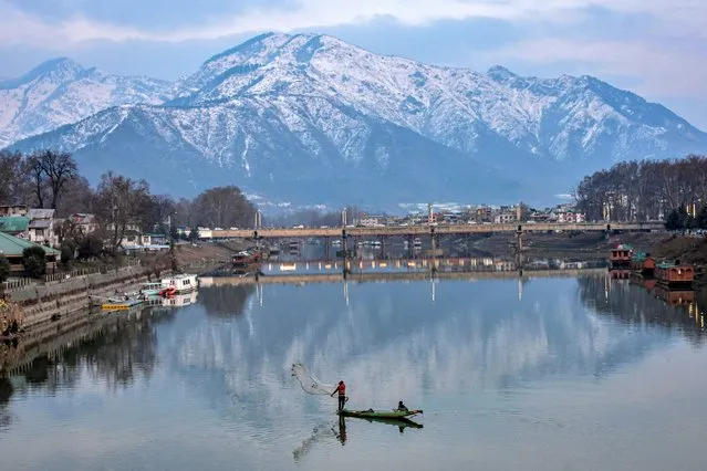 A fisherman casts his net into river Jhelum during a cold winter day in Srinagar on February 5, 2024. Weather across the Kashmir valley has improved after receiving fresh snowfall following prolonged dry weather. The flight operations at Srinagar Airport and road traffic on the Srinagar-Jammu highway that were hit by the snowfall on Sunday were restored on Monday. (Photo by Saqib Majeed/SOPA Images/Rex Features/Shutterstock)