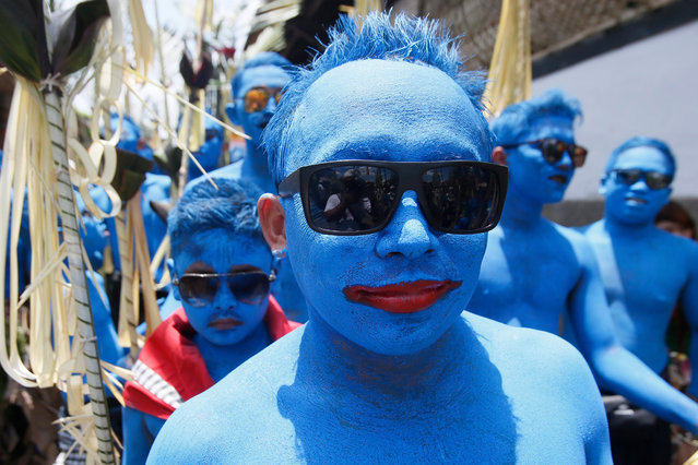 Balinese teenagers wear blue body as they take part in a sacred Ngerebeg ritual at a village in Gianyar, Bali, Indonesia, 16 March 2016. The sacred Ngerebeg ritual is staged every six months and is mainly aimed at driving all evil spirits out of the villages. During the ritual, participants decorate their body with colourful paint and march across the village. (Photo by Made Nagi/EPA)