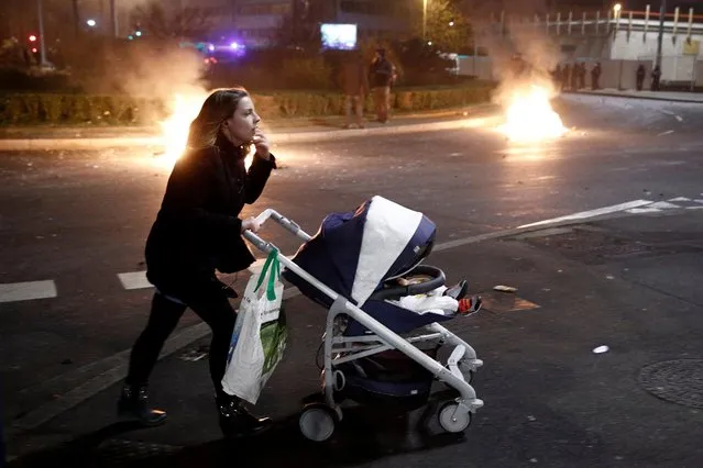 A woman pushes a baby stroller in front of burning barricades as protesters clash with French riot police in Bobigny, a suburb of Paris, France, 11 February 2017, after attending a demonstration in support of Theo, a young man who was hospitalised for an emergency surgery after he was allegedly sodomized with a truncheon during a police check. (Photo by Yoan Valat/EPA)