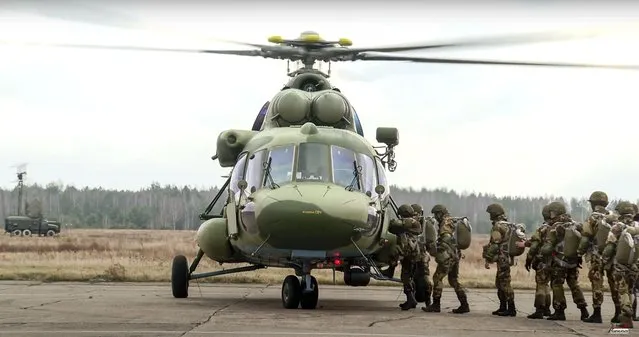 In this photo taken from video released by the Belarusian Defense Ministry Press Service on Friday, November 12, 2021, Russian and Belarusian paratroopers load into military helicopters near the border with Poland, Belarus, Russia has sent paratroopers to Belarus in a show of support for its ally amid the tensions over an influx of migrants on the Belarusian border with Poland. The Belarusian military said the exercise involving a battalion of Russian paratroopers was intended to test the readiness of the allies' rapid response forces due to an “increase of military activities near the Belarusian border”. (Photo by Belarusian Defense Ministry Press Service via AP Photo)