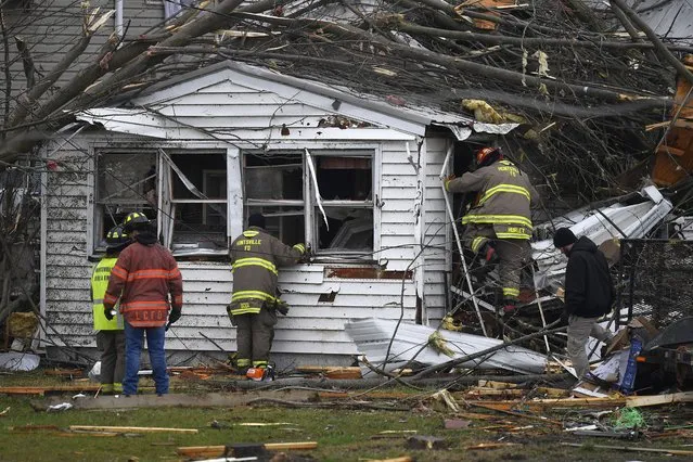 Members of the Huntsville Volunteer Fire Department enter a home to search for victims following a severe storm in Lakeview, Ohio., Friday, March 15, 2024. (Photo by Timothy D. Easley/AP Photo)
