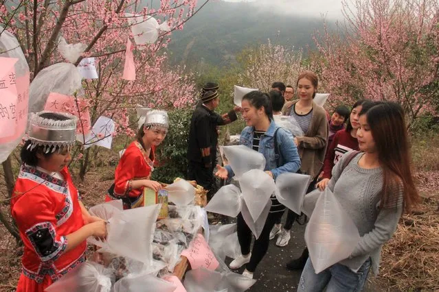 Locals sell to visitors plastic bags containing air collected at the mountainous environment protection zone in Qingyuan, Guangdong province, March 19, 2016. (Photo by Reuters/Stringer)