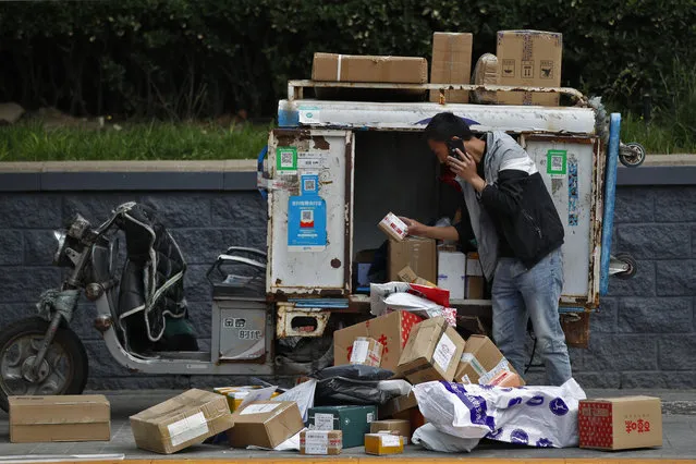 A private delivery company's courier sorts boxes of goods for his customers at the Central Business District in Beijing, Wednesday, May 8, 2019. Washington and Beijing have raised tariffs on billions of dollars of each other's exports, disrupting trade in goods from soybeans to medical equipment. Estimates of lost potential sales so far range as high as $25 billion. (Photo by Andy Wong/AP Photo)