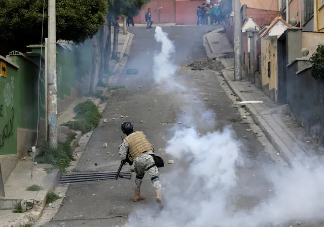 A riot policeman launches a tear gas canister towards coca growers from Yungas during the clashes in La Paz, Bolivia, February 21, 2017. (Photo by David Mercado/Reuters)