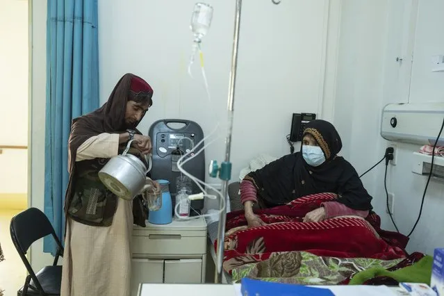 A Afghan man prepares tea for a relative being treated for COVID-19 in the emergency ward of the Afghan-Japan Hospital, in Kabul, Afghanistan, on Thursday, December 9, 2021. (Photo by Petros Giannakouris/AP Photo)