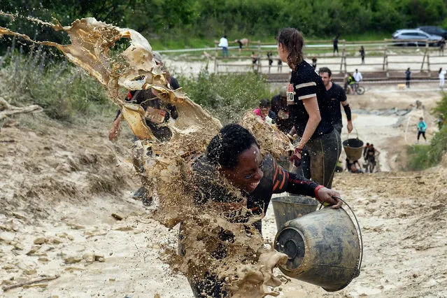 Mud is thrown at runners as they take part in the Mud Day, a 13km race with obstacles in Beynes, near Paris on June 16, 2019. (Photo by Alain Jocard/AFP Photo)